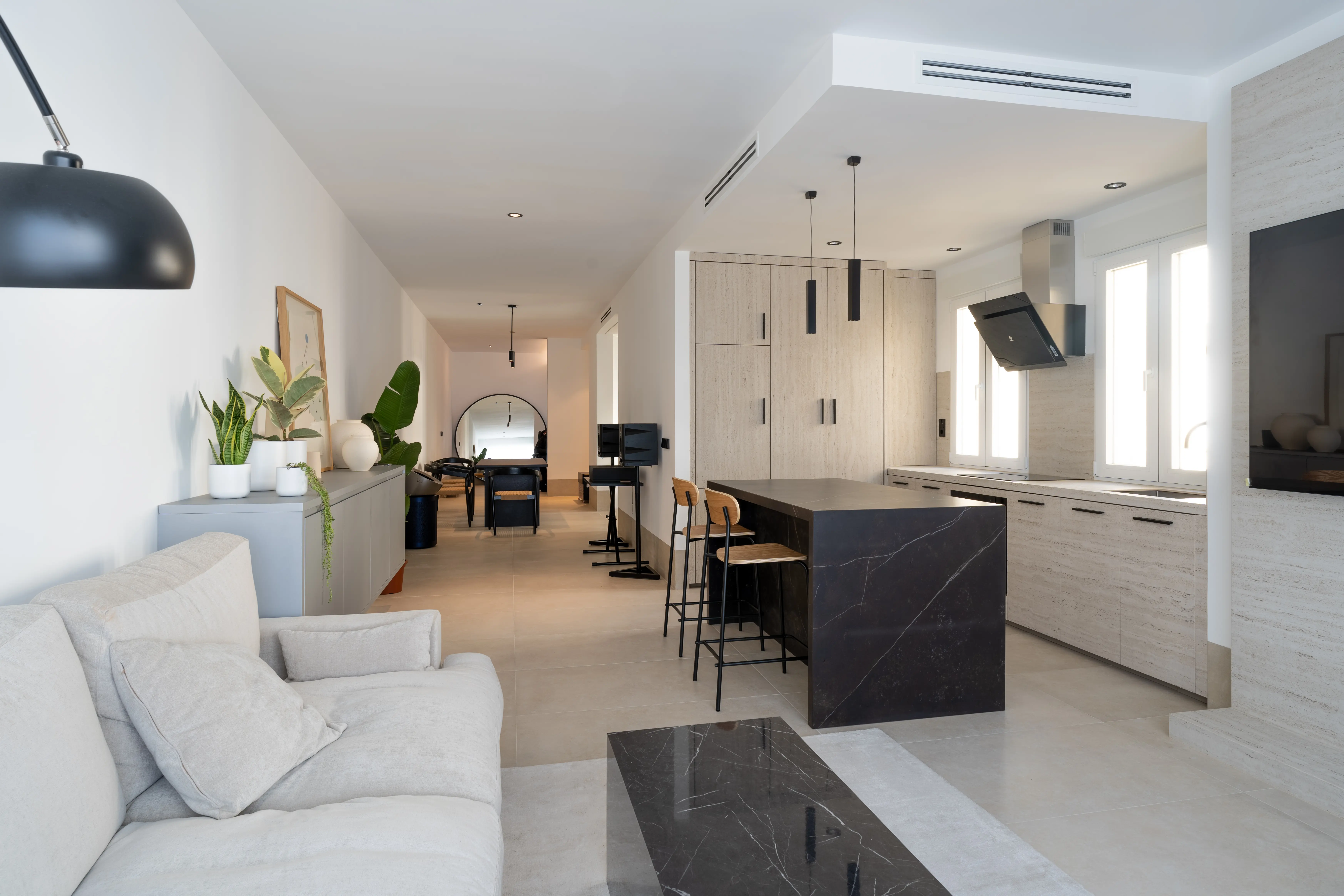 Salón y cocina reformados con isla, muebles de madera y luz natural