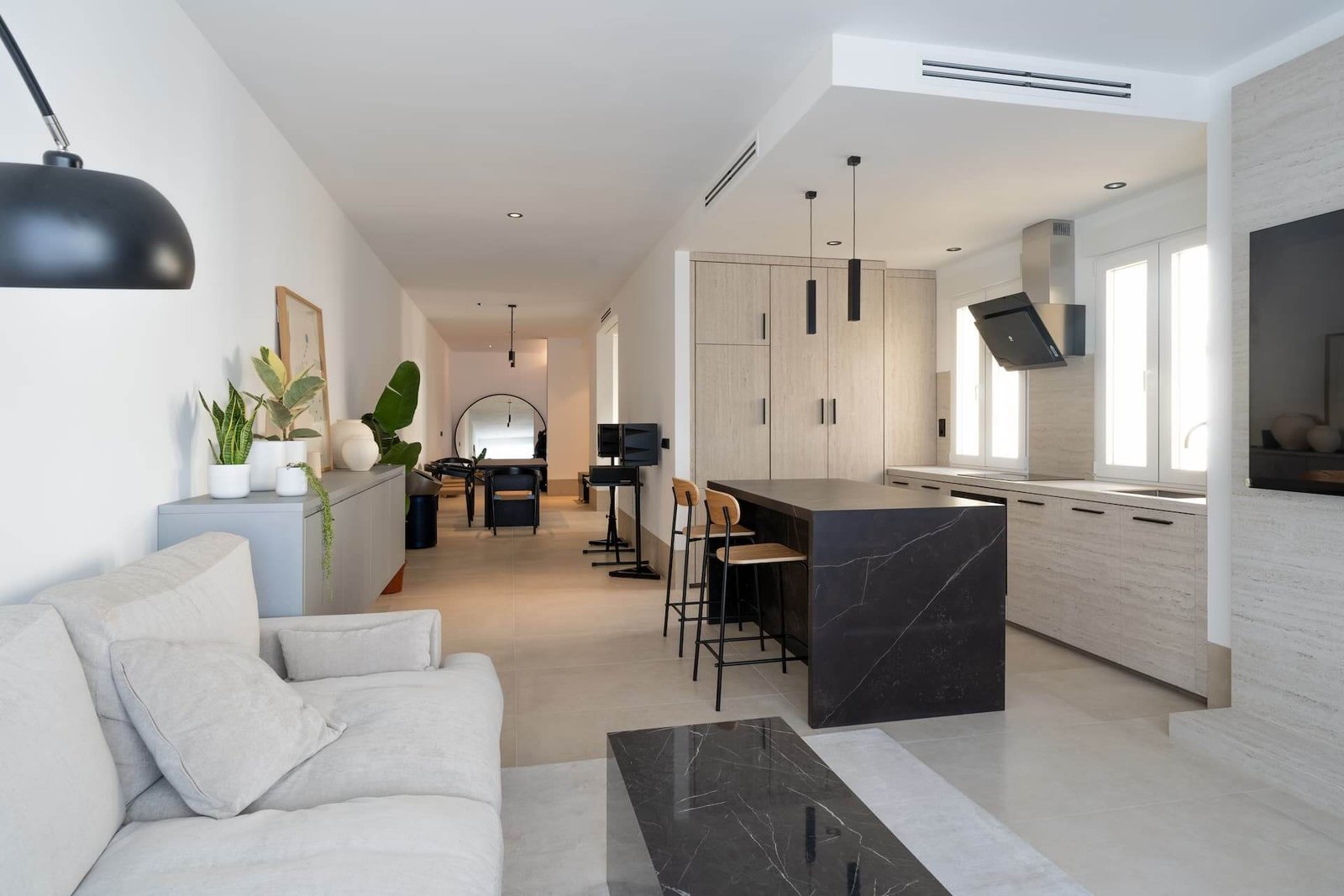 Salón y cocina reformados con isla, muebles de madera y luz natural